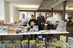 Shown (from left) are: Shawmut executives Roger Tougas, Marianne Monte, Les Hiscoe and Kevin Sullivan wrapping some of the 1,300 toys Shawmut donated this holiday season through Project Happier Holidays.