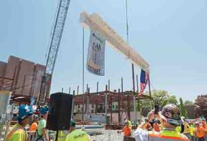 A beam signed by hundreds of members of the Brown University community is raised into place during a topping off ceremony held for the 80,000 s/f School of Engineering building, located at 345 Brook Street - Providence, RI
